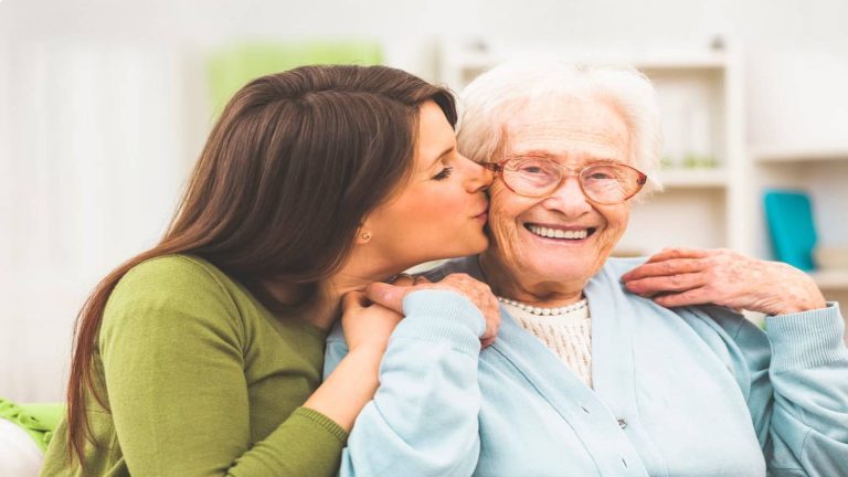 Family member kissing aging loved one on cheek
