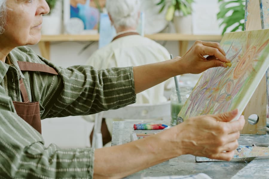 Senior resident making art with pastel chalk