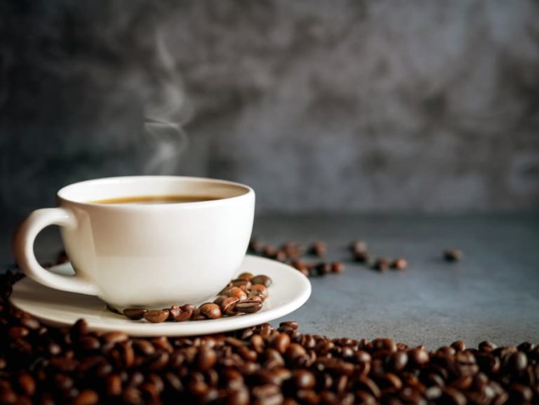 Coffee cup and coffee beans on gray background