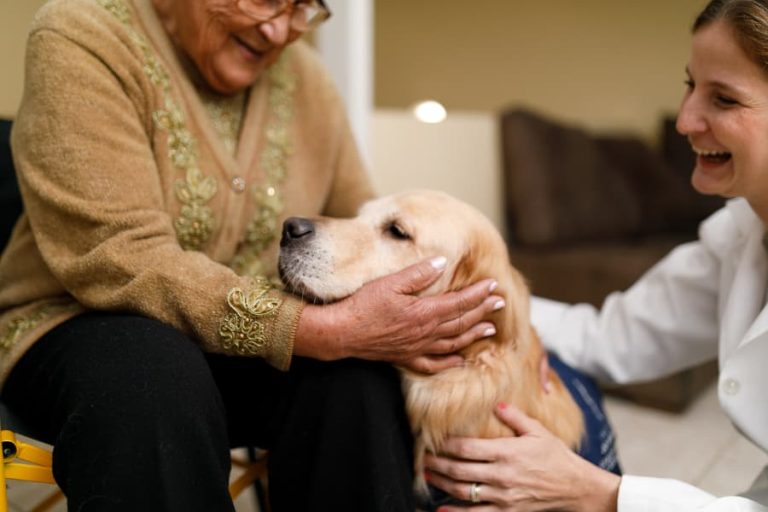 Senior and caregiver with therapy dog at home