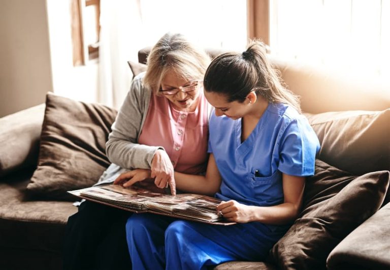 Nurse and resident looking at photo album together