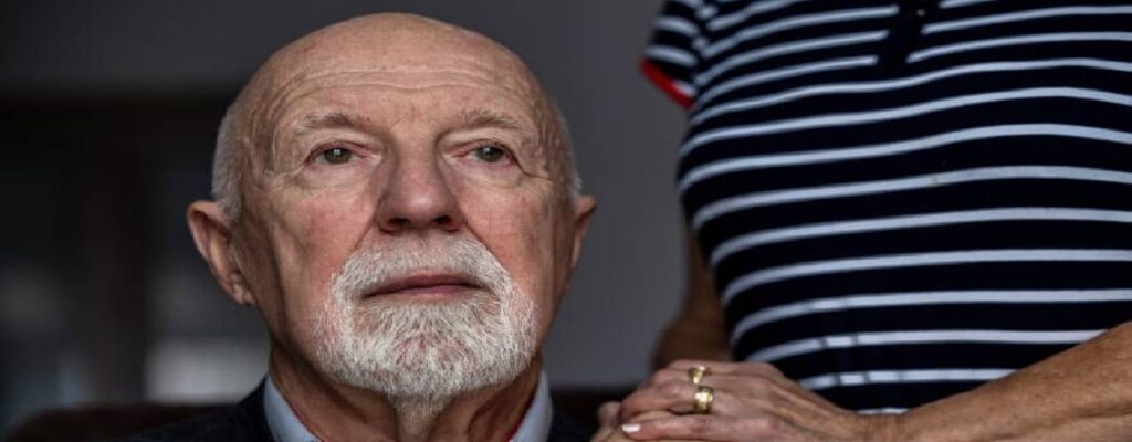 Senior looking solemn while holding hand of partner