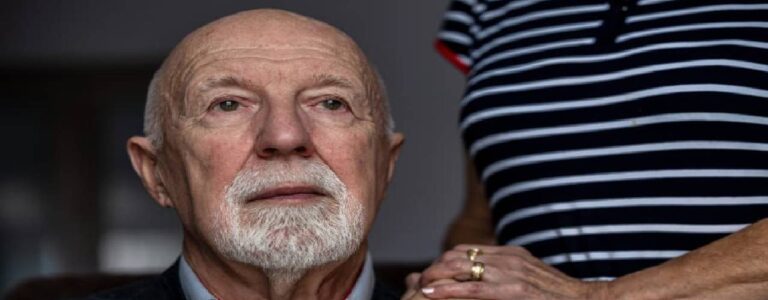 Senior looking solemn while holding hand of partner