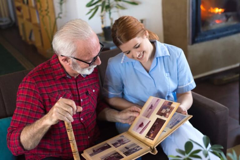 Resident looking through photo album with nurse