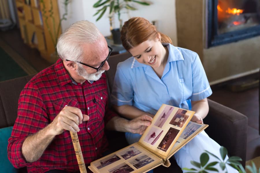 Resident looking through photo album with nurse