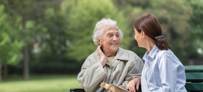 Senior sitting with caregiver in park