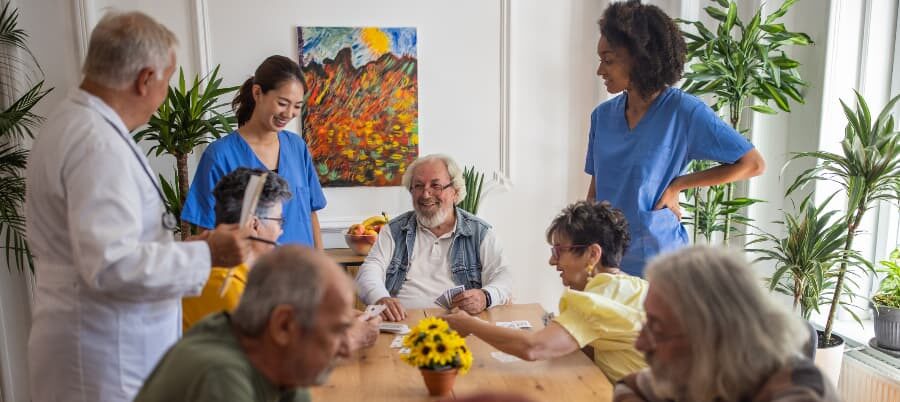 Happy residents playing cards in nursing home