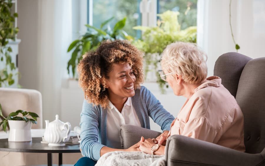 Caregiver talking with resident sitting in living room