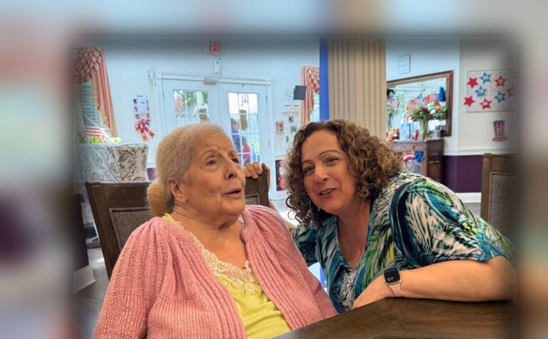 A Fox Trail memory care resident in conversation with a team member at a dining table in one of our communities