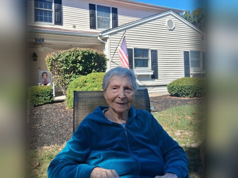 A Fox Trail memory care resident sitting outside one of our New Jersey homes on a sunny afternoon